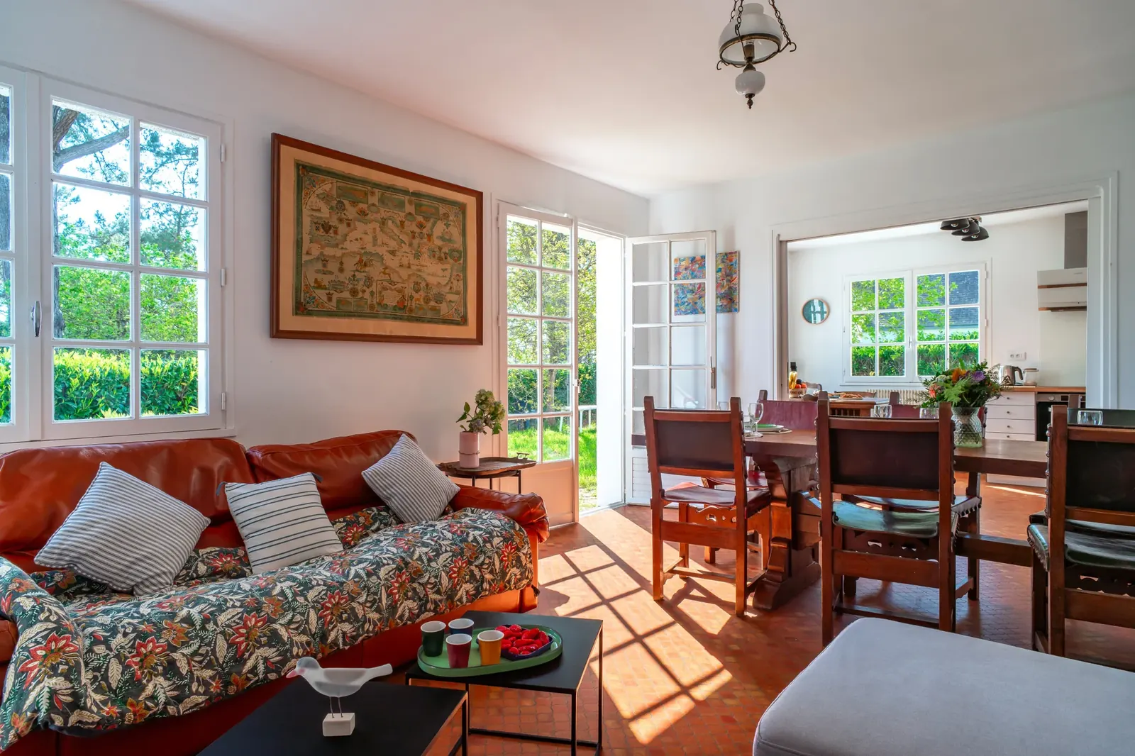 Salon, grande table et cuisine ouverts sur le jardin
